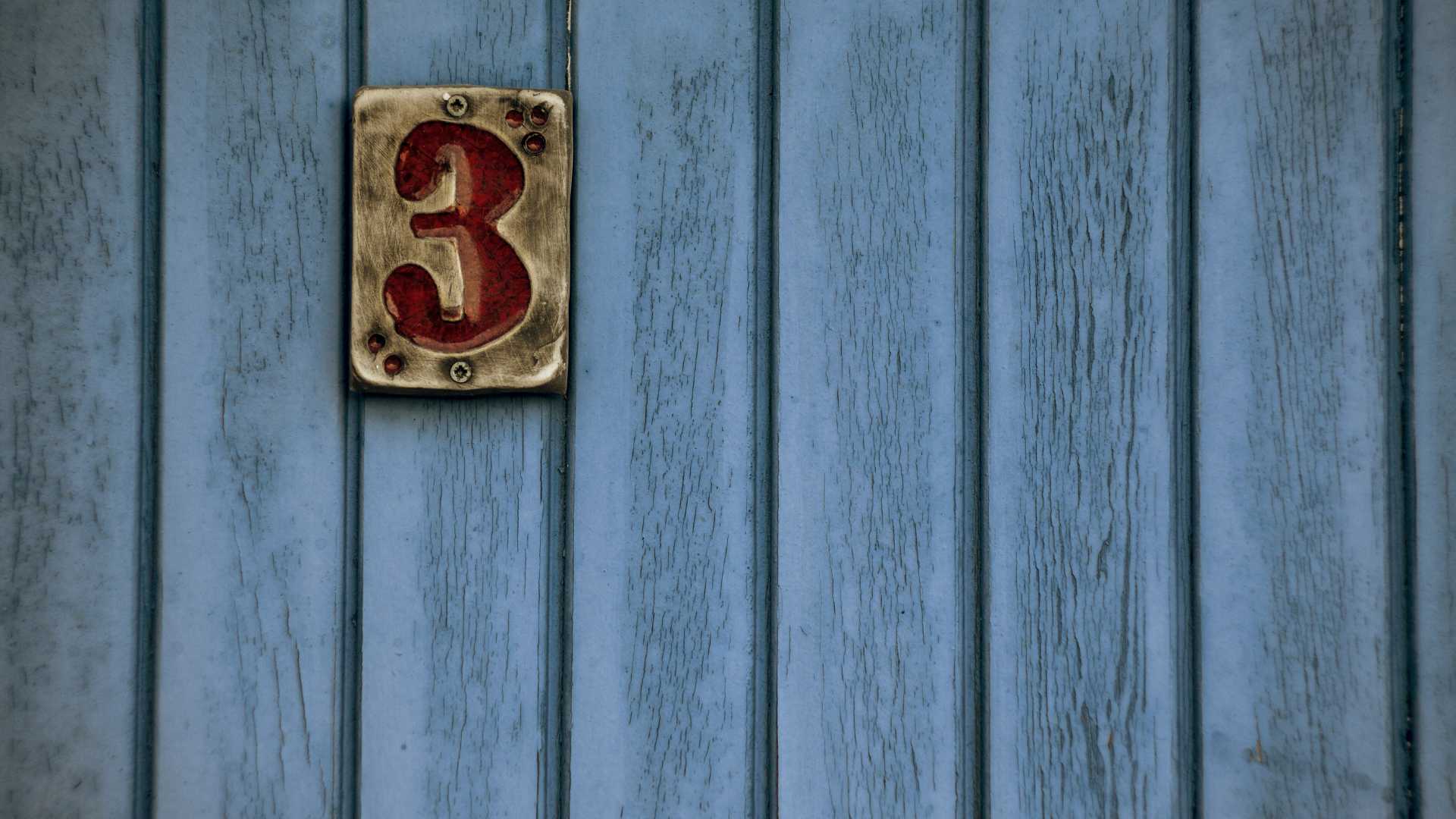 Chiffre 3 sur du bois bleu