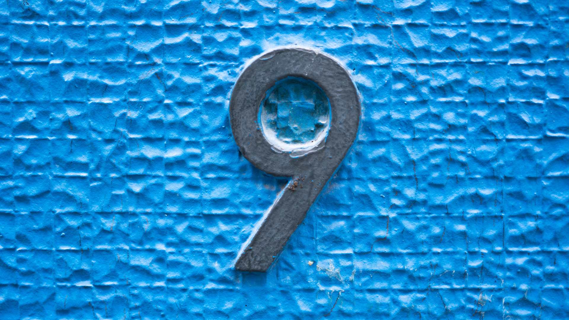 chiffre 9 sur mur bleu